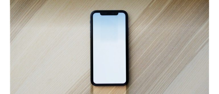белый смартфон на коричневом деревянном